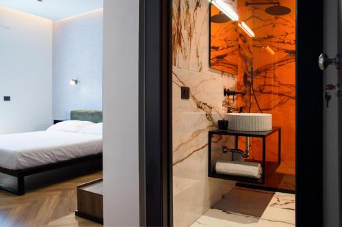een slaapkamer met een bed en een badkamer met een wastafel bij Adriatic Luxury Suites in Pescara