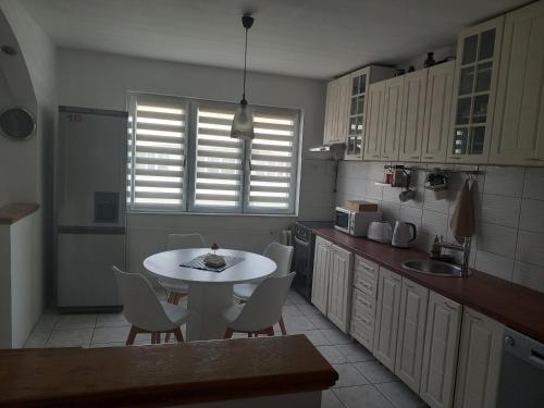 a kitchen with a white table and chairs in it at Adriana's Apartment in Skopje
