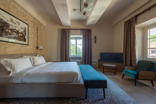 a hotel room with a bed and a chair at Grand Universe La Residenza in Lucca