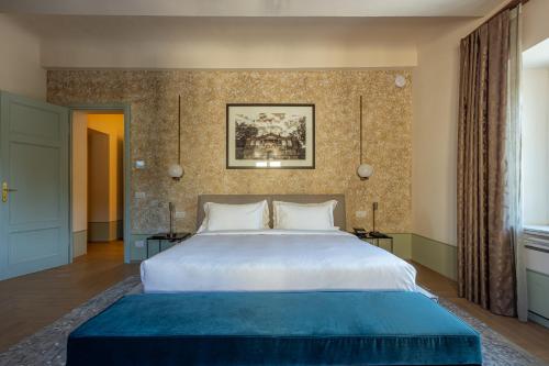 a bedroom with a large bed with a blue blanket at Grand Universe La Residenza in Lucca