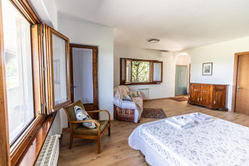 1 dormitorio con 1 cama y 1 silla en una habitación en Affittacamere Cigui, en Muggia