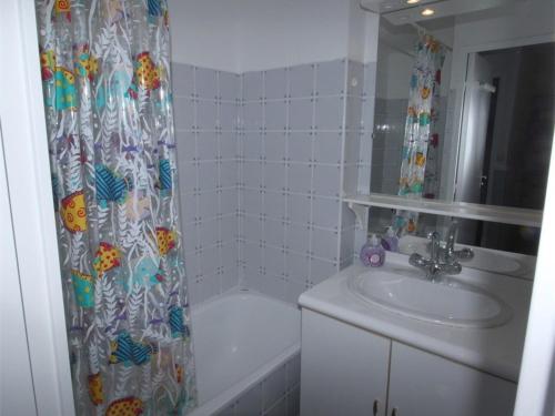 une salle de bain avec un lavabo et un rideau de douche dans l'établissement Appartement 2 Pièces avec Cabine, Parking, Internet - Bagnères-de-Luchon - FR-1-313-159, à Luchon