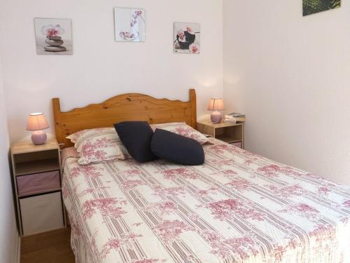 une chambre avec un lit avec deux tables de nuit et deux lampes dans l'établissement Luchon: Appartement 2 chambres proche thermes, balcon, parking, WiFi - Animaux <10kg acceptés - FR-1-313-186, à Luchon