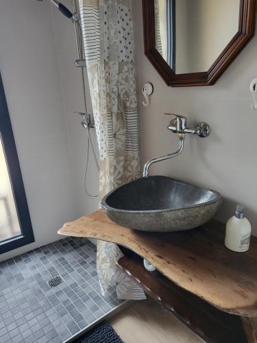 a bathroom with a stone sink and a mirror at KERHAM in Plouay
