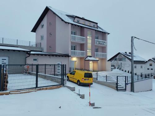 a yellow van parked in front of a building at Apartment Una in Kupres