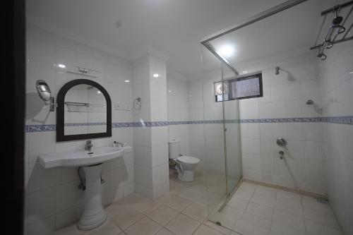 a bathroom with a sink and a shower and a toilet at Hotel Bhagavath Gardens in Chengannūr