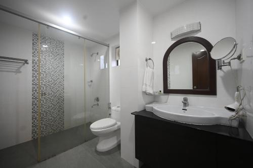 y baño con lavabo, aseo y espejo. en Hotel Bhagavath Gardens, en Chengannūr