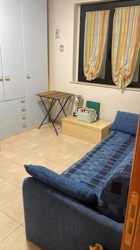 a living room with a blue couch and a table at Casa vacanze in Campomarino