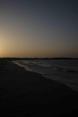 a view of the beach at sunset with the ocean at Casa vacanze in Campomarino