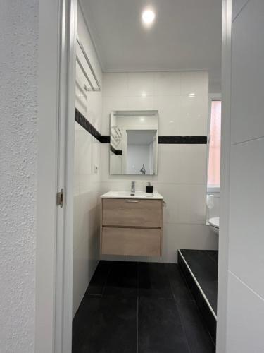 ein Bad mit einem Waschbecken und einem Spiegel in der Unterkunft En el corazón de Santander in Santander