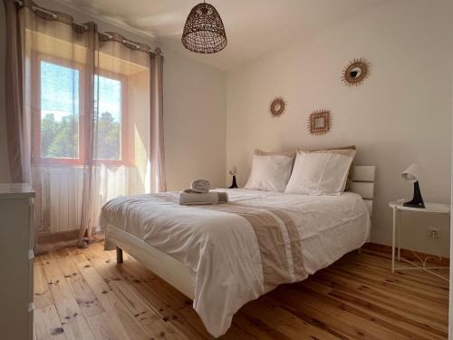 una camera da letto con un letto grande e una grande finestra di Chez Marie ad Albaret-Sainte-Marie