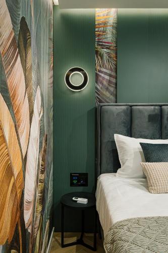 a bedroom with a bed and a green wall at IDEA LUX Apartmani Kragujevac in Kragujevac