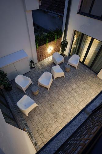 a group of white benches sitting on a patio at IDEA LUX Apartmani Kragujevac in Kragujevac