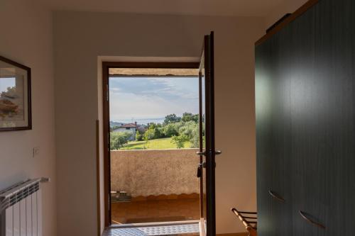 a door to a balcony with a view of a yard at Affittacamere Cigui in Muggia