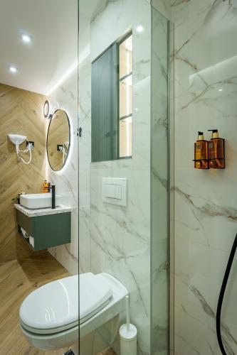 a bathroom with a toilet and a glass shower at IDEA LUX Apartmani Kragujevac in Kragujevac
