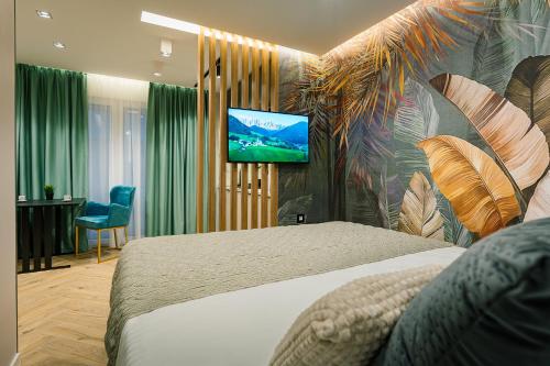 a bedroom with a bed and a television on a wall at IDEA LUX Apartmani Kragujevac in Kragujevac