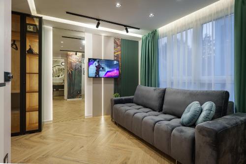 a living room with a couch and a flat screen tv at IDEA LUX Apartmani Kragujevac in Kragujevac