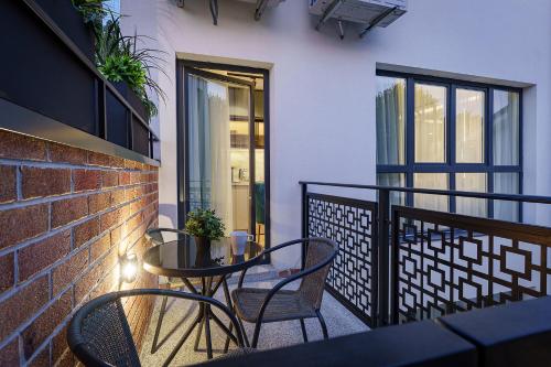 a balcony with a table and chairs and a brick wall at IDEA LUX Apartmani Kragujevac in Kragujevac