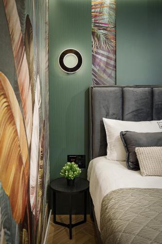 a bedroom with a bed and a table with flowers on it at IDEA LUX Apartmani Kragujevac in Kragujevac