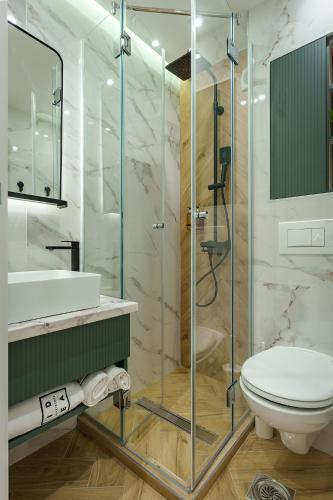 a bathroom with a toilet and a glass shower at IDEA LUX Apartmani Kragujevac in Kragujevac