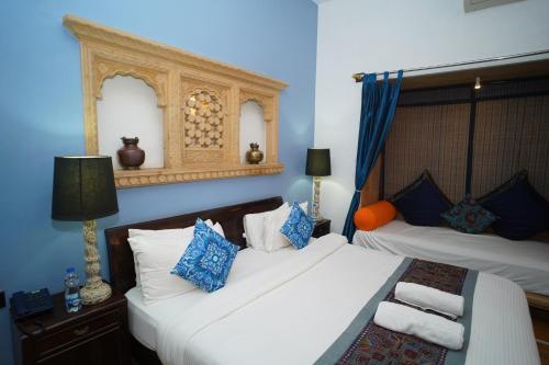 two beds in a room with blue walls at Hotel Jaisan Haveli in Jaisalmer