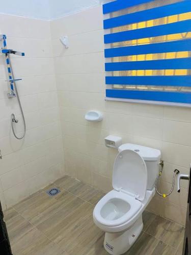 a bathroom with a white toilet and a shower at 2 Chambres salon meublés in Cotonou