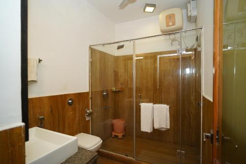 a bathroom with a shower and a toilet and a sink at Hotel Jaisan Haveli in Jaisalmer