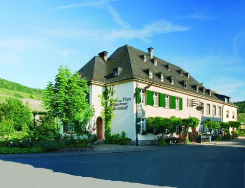 a large white building with a black roof at Seminarshof in Trittenheim