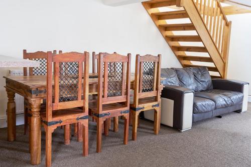 a dining room with a table and chairs and a couch at The Barn (Chilsworthy), 6 Sleeper House, 19 Min Drive into Bude, Cornwall in Holsworthy