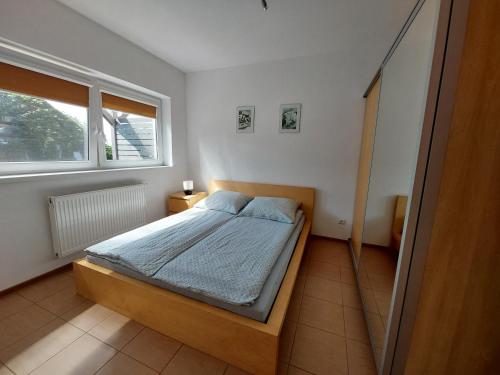 a bedroom with a bed and a window at Domki Letniskowe Flauta in Grzybowo