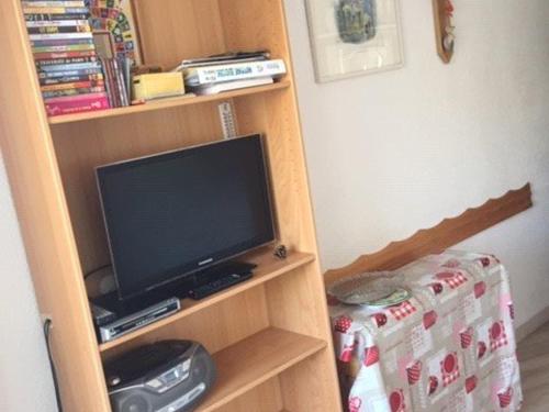 - une télévision dans une étagère dans l'établissement Studio cosy pour 4 pers. au pied des pistes, Arette - Balcon, ascenseur, casier à skis, parkings gratuits - FR-1-602-91, à Arette