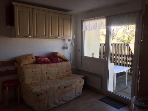 un salon avec un canapé et une porte coulissante en verre dans l'établissement Studio cosy pour 4 pers. au pied des pistes, Arette - Balcon, ascenseur, casier à skis, parkings gratuits - FR-1-602-91, à Arette