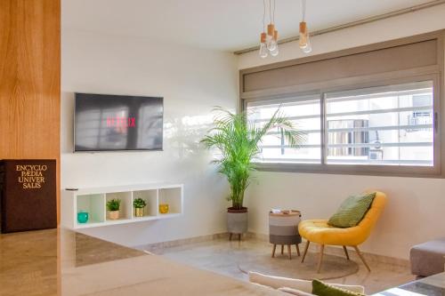 a living room with a yellow chair and a window at Luxury Apartment 3 Bedroom in the Heart of Agdal near Arribat Center in Rabat