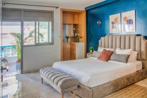 ラバトにあるLuxury Apartment 3 Bedroom in the Heart of Agdal near Arribat Centerの青い壁のベッドルーム1室(大型ベッド1台付)