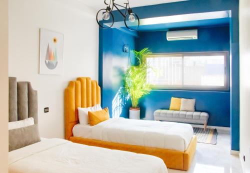 zwei Betten in einem Zimmer mit blauen Wänden in der Unterkunft Luxury 3 Bedroom Apartment in the Heart of Agdal Renovated Jan 2025 in Rabat