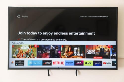 a flat screen tv sitting on a wall at Luxe Cosy&Spacious 2 Bed House - Super Fast Wi-Fi & Private Parking Near GLO Airport & Cheltenham Racecourse in Churchdown
