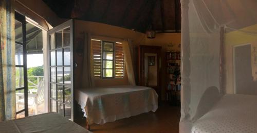 a bedroom with a bed and a window and a door at I VIEW - in Long Bay in Long Bay Village