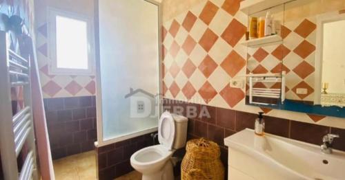 a bathroom with a toilet and a sink at Mille & une nuit in Al Maqārisah