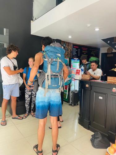 a man with a backpack standing in a store at Saigon Hub Hostel in Ho Chi Minh City