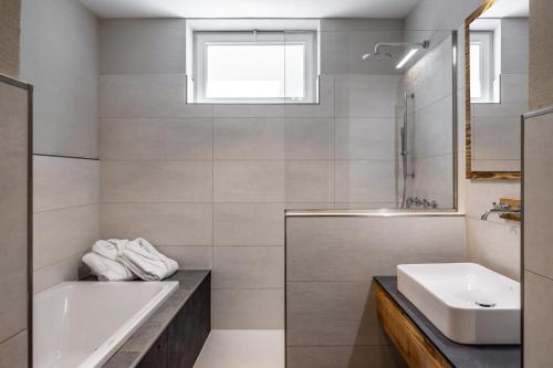a bathroom with a tub and a sink and a bath tub at Camping Essenza Alpina in Folgaria