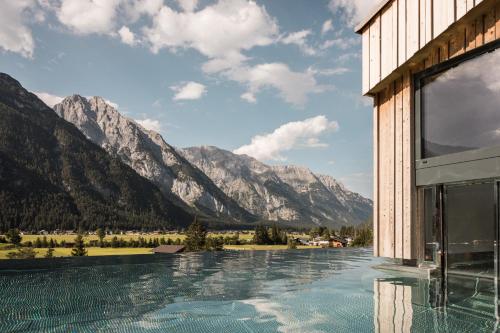 a view of the mountains from a hotel swimming pool at Hotel Kristall - Adults only in Leutasch