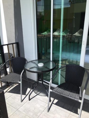 a glass table and two chairs on a porch at Anantra Pattaya Resort in Pattaya Central