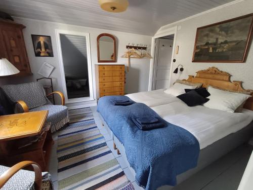 a bedroom with a large bed with a blue blanket on it at Flodhästens Husrum & Frukost in Varberg