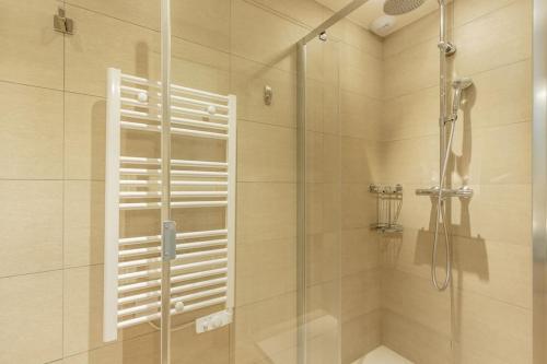une douche avec une porte vitrée dans une salle de bain dans l'établissement Appartement Haute gamme ski aux pieds, piscine, sauna., à Bourg-Saint-Maurice