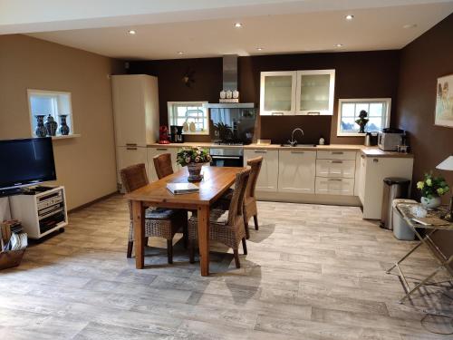 a kitchen with a wooden table and chairs at De Riekhoff in Een-West