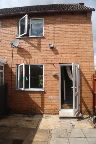 a brick building with two windows and a door at Luxe Cosy&Spacious 2 Bed House - Super Fast Wi-Fi & Private Parking Near GLO Airport & Cheltenham Racecourse in Churchdown