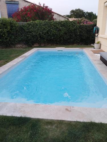 une grande piscine bleue dans une cour dans l'établissement Villa J et V, à Bédarrides