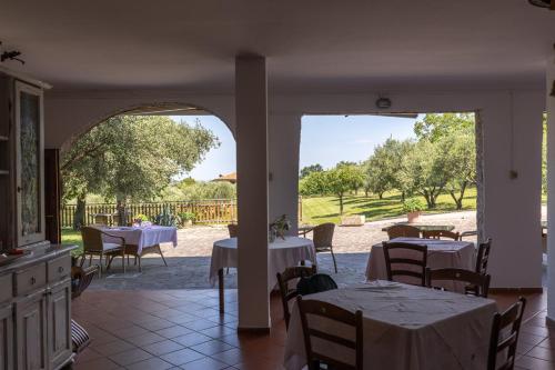 a dining room with tables and chairs and an open door at Affittacamere Cigui in Muggia