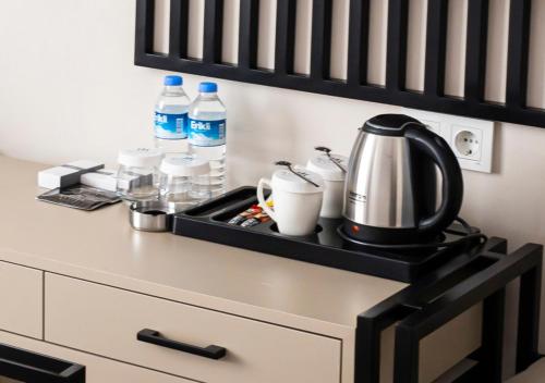 a kitchen counter with a tea kettle and bottles of water at Monezza Hotel Maltepe in Istanbul