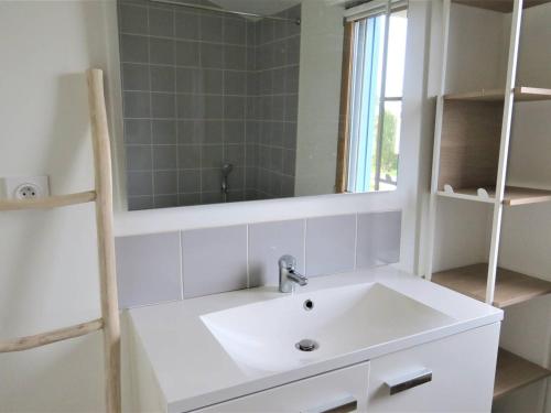 une salle de bain avec un lavabo blanc et un miroir dans l'établissement Maison à Trégastel : WIFI, jardin, terrasse sud, proche plage, calme - FR-1-368-333, à Trégastel